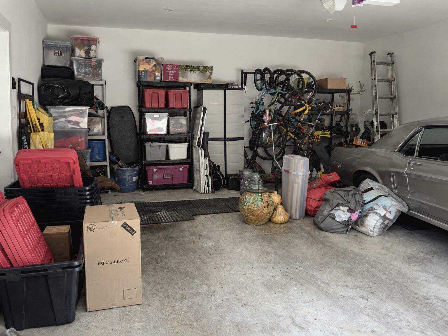 Garage before: bins, boxes, bikes and bags spread across the floor